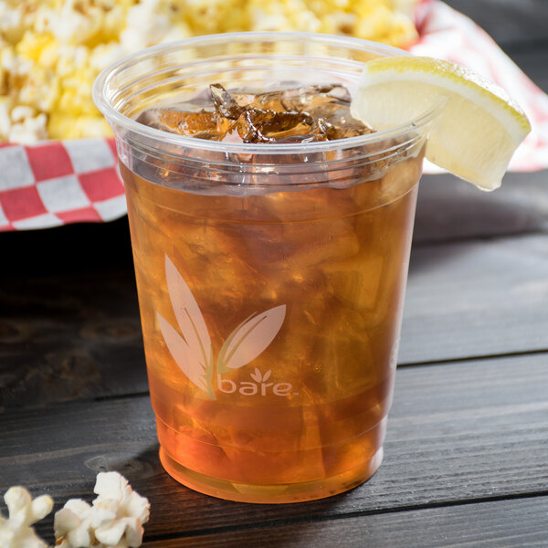 A Bare by Solo RPET plastic cup filled with iced tea with a lemon wedge.