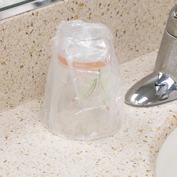 A plastic cup in a plastic bag on a counter.