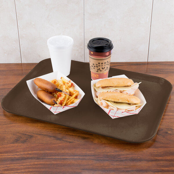 A Carlisle Glasteel tray with hot dogs, fries, and a drink on a table.