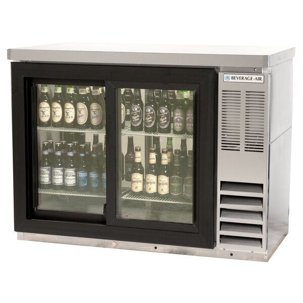 A Beverage-Air stainless steel pass through back bar cooler with beer bottles inside.