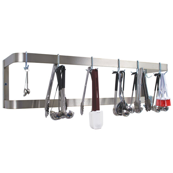 A stainless steel wall mounted double line pot rack with cooking utensils hanging from it.
