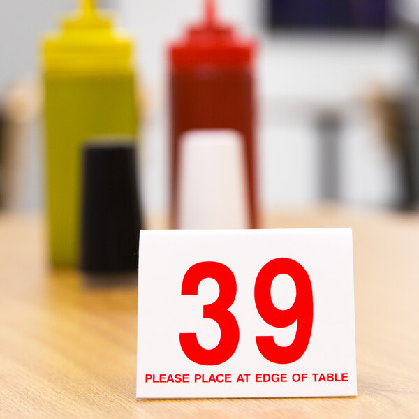 A white Cal-Mil table tent with red numbers reading "26-50" on a table.