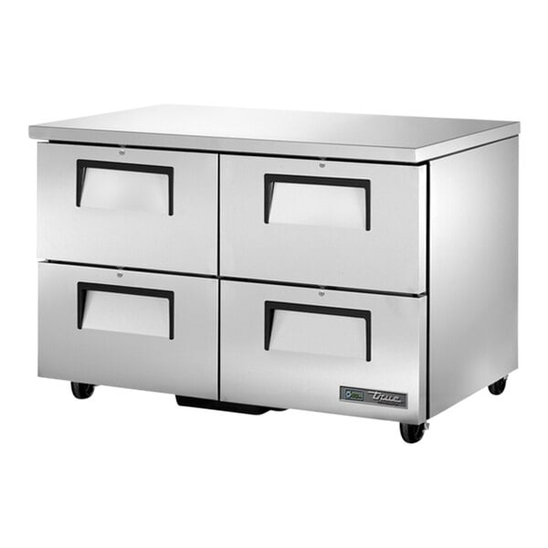 A silver metal True undercounter refrigerator cabinet with four drawers on wheels.
