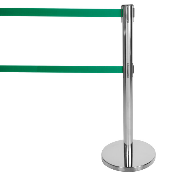 A silver metal Aarco crowd control stanchion with dual green retractable belts.
