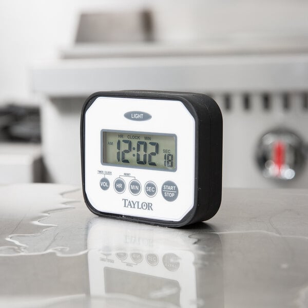 A Taylor digital clock and kitchen timer on a counter.