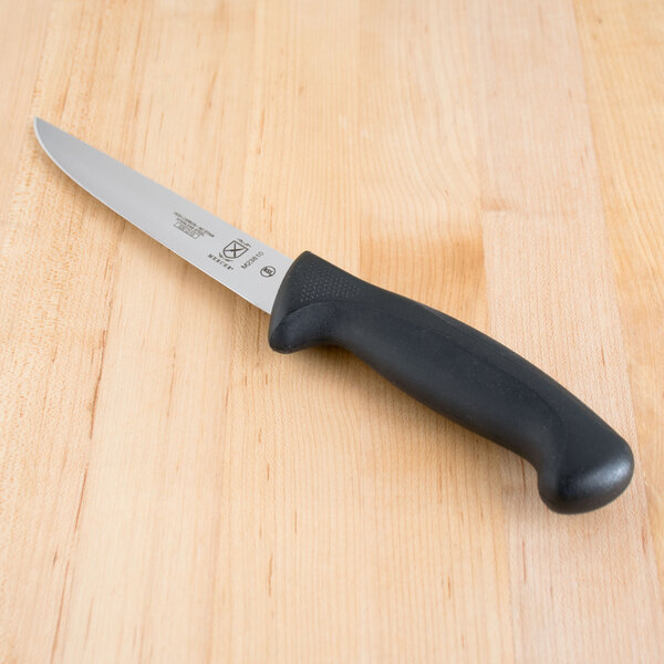 A Mercer Culinary Millennia Boning Knife with a black handle on a wooden table.