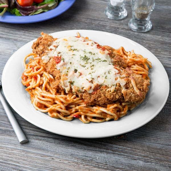 A Diamond White narrow rim plate with spaghetti, chicken, and cheese on it.