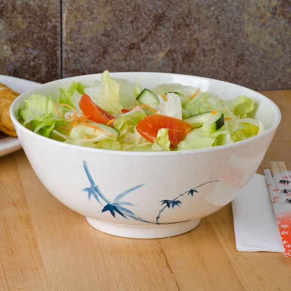 A Blue Bamboo melamine rice bowl filled with salad on a table.