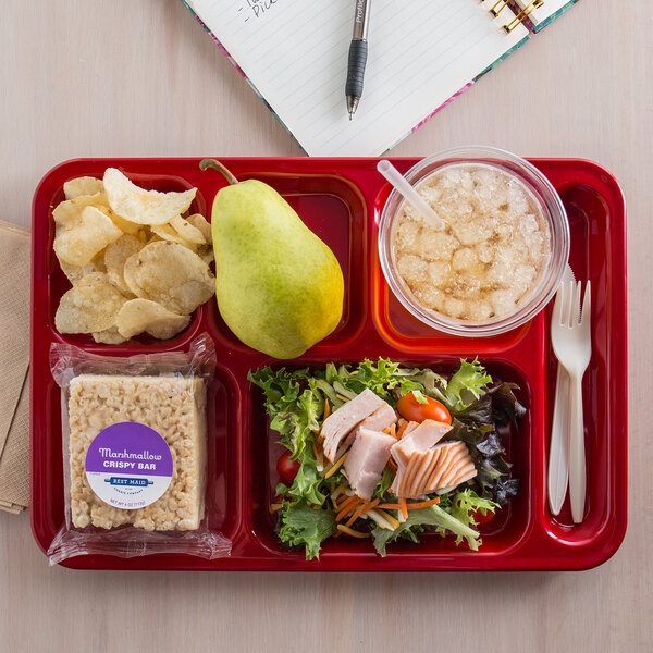 A Carlisle red 6 compartment tray with a sandwich, chips, and a pear on a table.