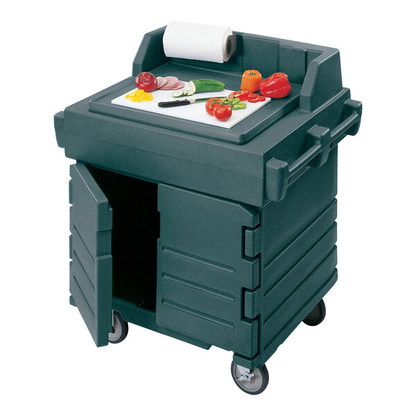 A granite green Cambro CamKiosk food preparation cart on a table with food on it.