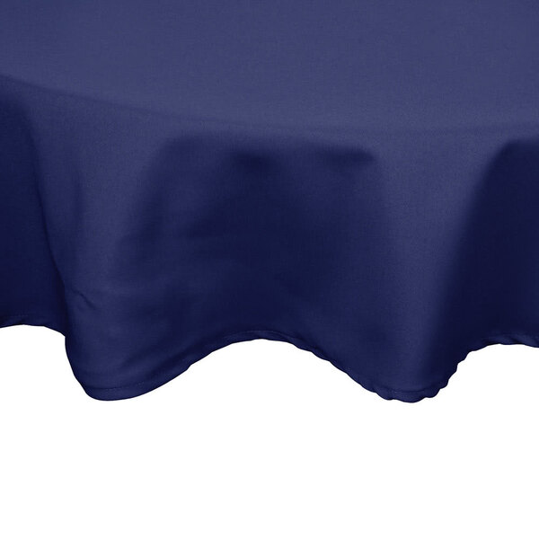 A navy blue hemmed round table cover on a table.