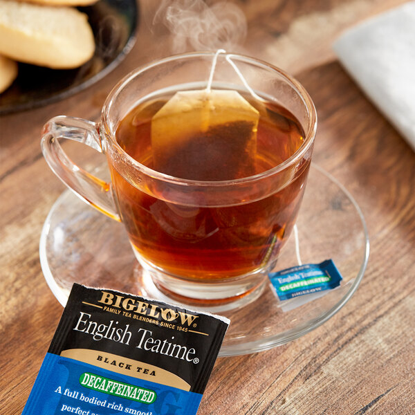 A cup of Bigelow English Teatime decaffeinated tea with a tea bag on a saucer.
