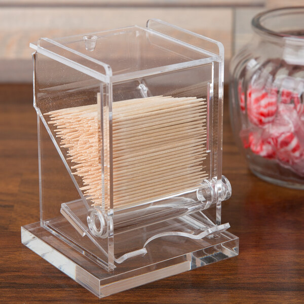 A clear plastic container with toothpicks in it.