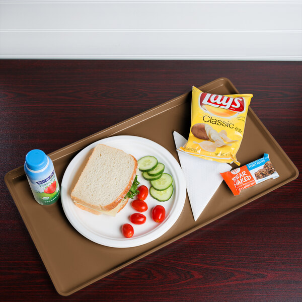 A Cambro suede brown dietary tray with a sandwich, chips, and a drink on it.
