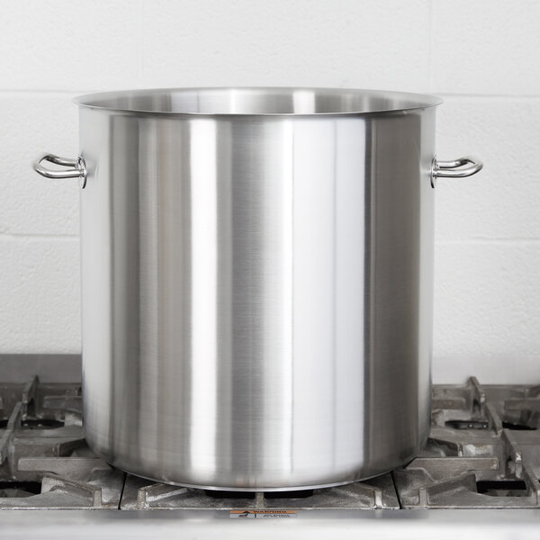 A Vollrath stainless steel stock pot on a stove.