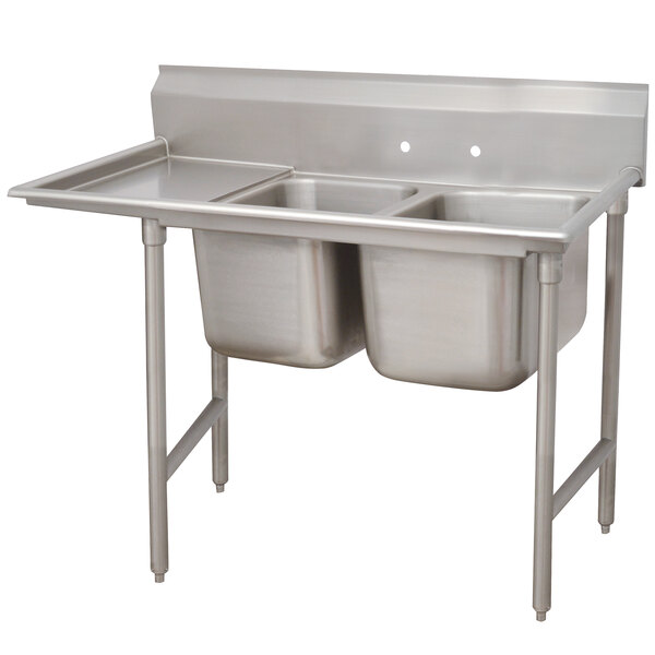 An Advance Tabco stainless steel 2-bowl sink with one drainboard on the left.