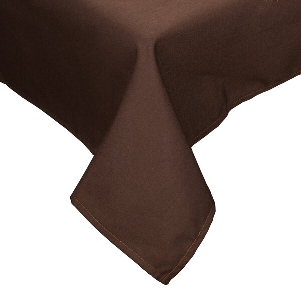 A brown Intedge rectangular tablecloth with a hemmed edge on a table in a fine dining restaurant.