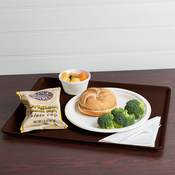 A Cambro Brazil brown hospital dietary tray with a sandwich, broccoli, and chips.