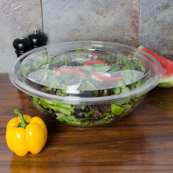 A salad in a Sabert FreshPack clear plastic bowl with yellow peppers.