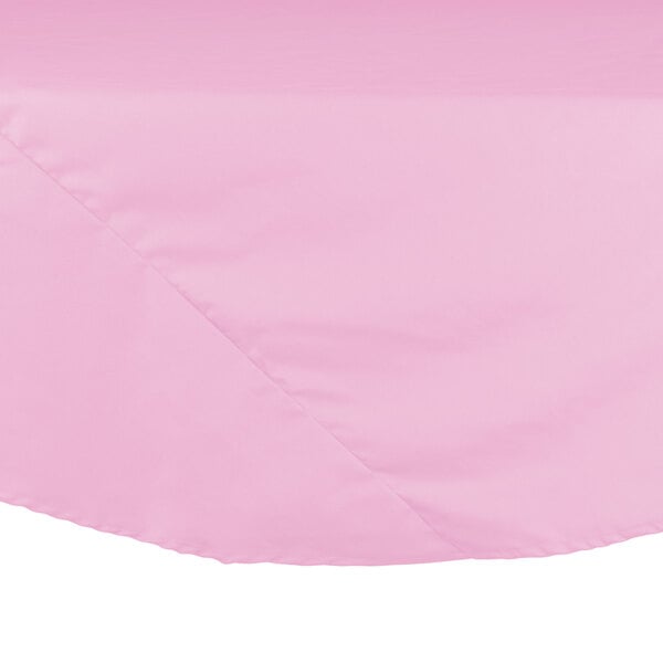 A pink Intedge round poly/cotton blend tablecloth on a table.