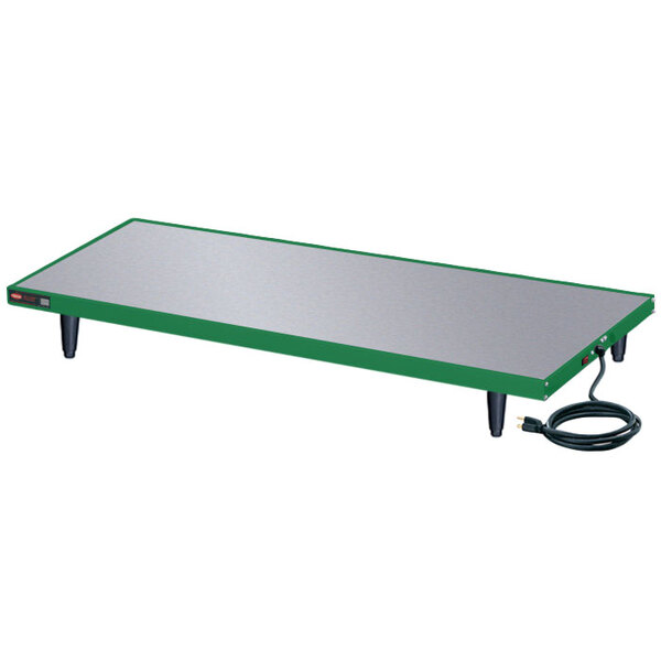 A green and black rectangular Hatco heated shelf with a cord attached.