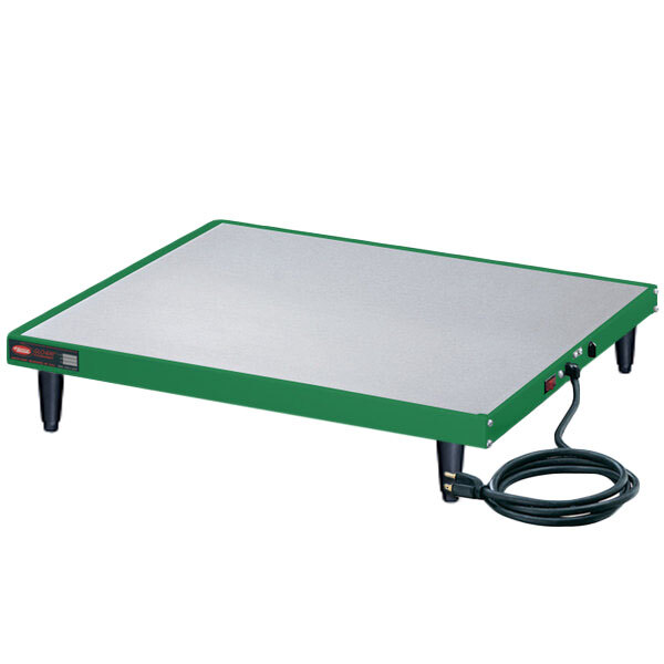 A green and white rectangular Hatco heated shelf with a black cord.