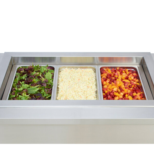 A Wells stainless steel dual temperature food well with three pans in a counter.