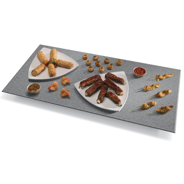 A gray Hatco heated stone shelf with a tray of food and a plate of ribs on a table.