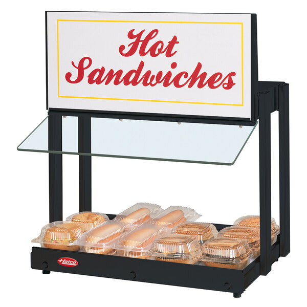 A Hatco mini-merchandising warmer on a countertop with a sign that says "Hot Sandwiches".