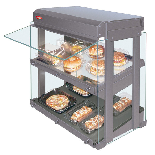 A Hatco mini-merchandising warmer with slanted shelves holding food trays.