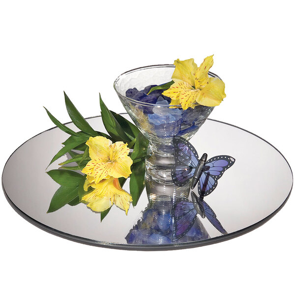 A Cal-Mil mirror tray with a glass bowl of flowers and butterflies on it.