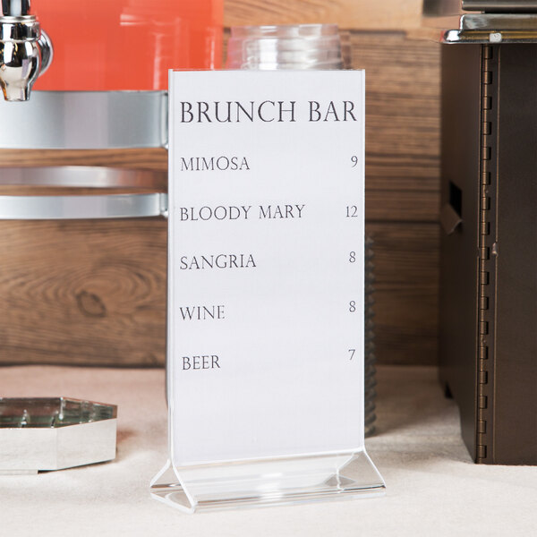 A Cal-Mil acrylic displayette with a wine menu on a counter.