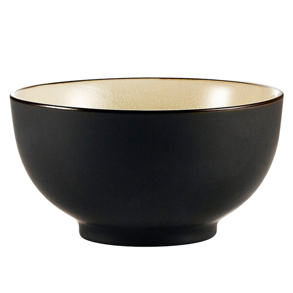 A black CAC stoneware rice bowl with a white rim.