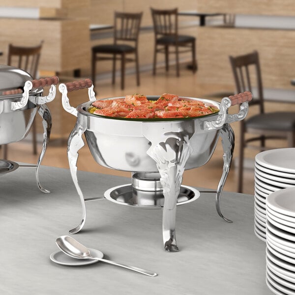 A Choice Classic round chafing dish on a table with food and silverware.