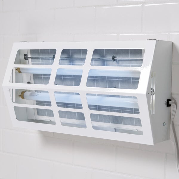 A white rectangular Curtron Pest-Pro UV flying insect control light fixture on a white tile wall.