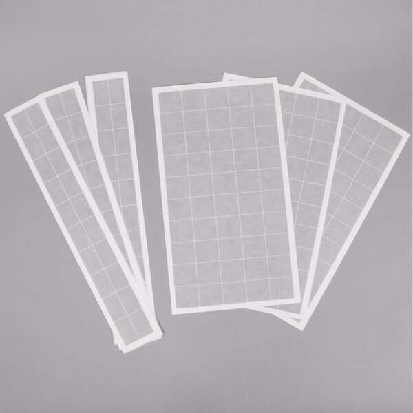 White paper with grid squares, 2 large and 8 small white rectangles, and a white Curtron insect trap glue board.