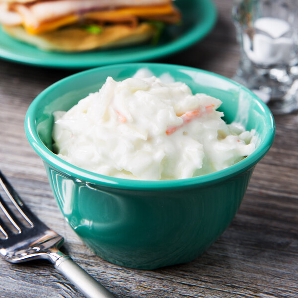 A bowl of coleslaw with a fork in a GET Diamond Mardi Gras melamine bowl.