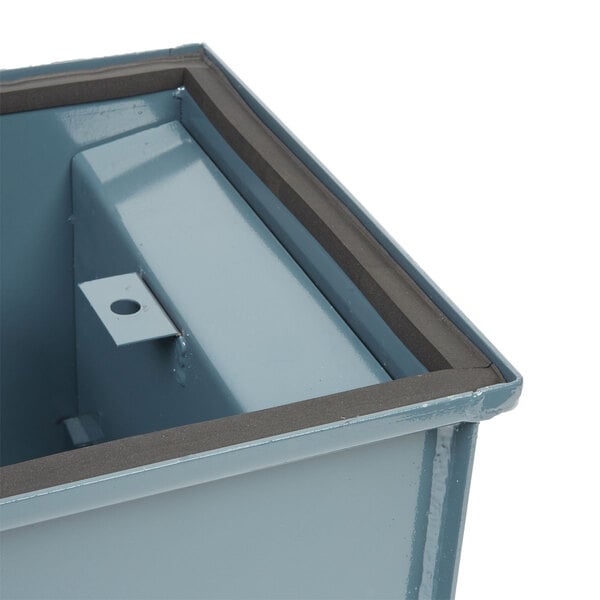 A blue metal Watts gasket on a metal box lid.