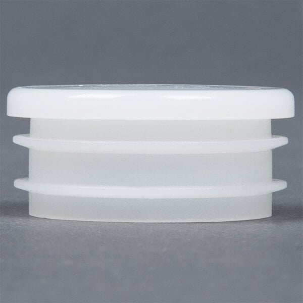 A white plastic container of Lancaster Table & Seating chair glides with three different sizes.