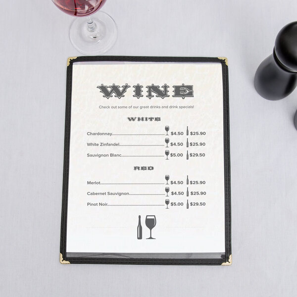 An 8 1/2" x 11" menu with a southwest desert design on a table with a glass of wine.
