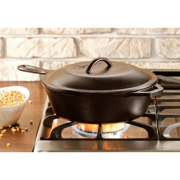 A Lodge cast iron skillet with a lid on a stove.