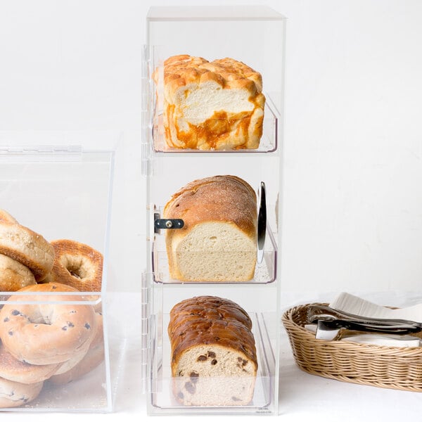 A Cal-Mil bread box filled with three sections of bread on a bakery display counter.