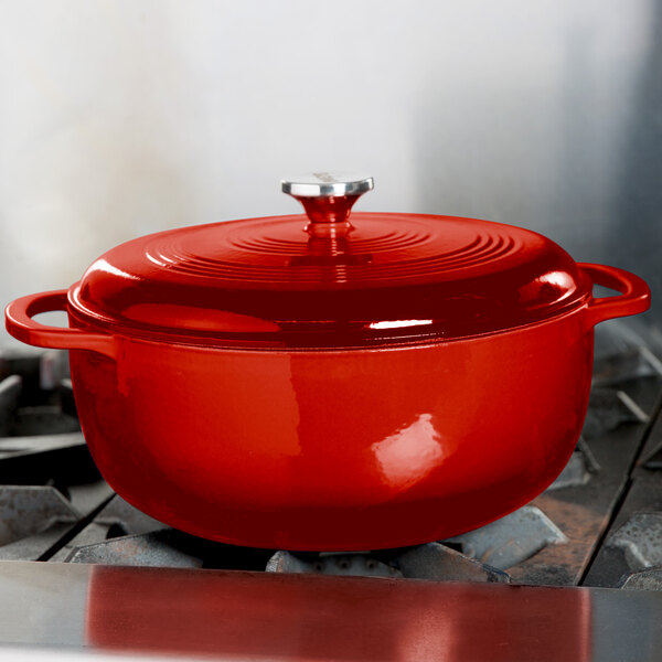 A red Lodge enameled cast iron Dutch oven on a stove.
