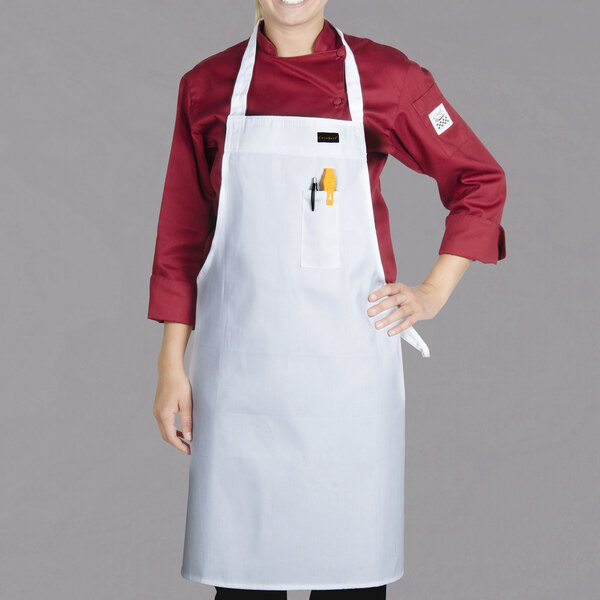 A woman wearing a white Chef Revival bib apron.