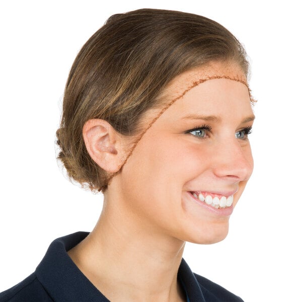 A woman smiling with a Chef Revival blonde hairnet on her head.
