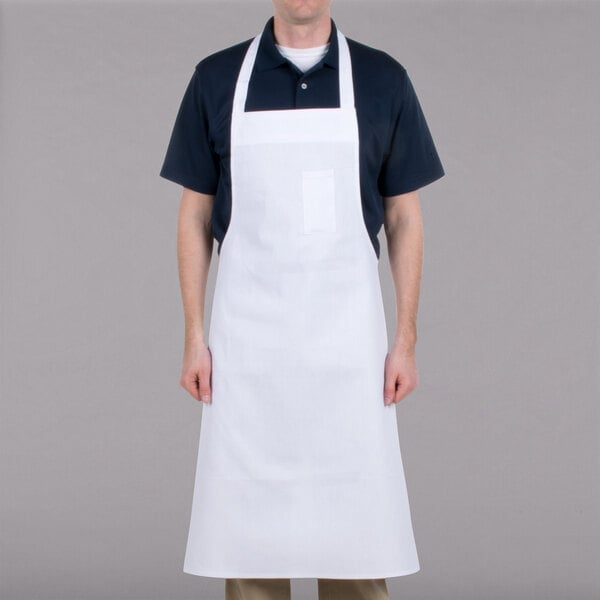 A man wearing a white Chef Revival apron with a pen pocket.