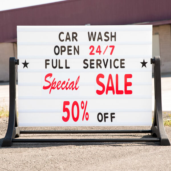An Aarco white roadside A-Frame sign with a stand and text advertising a car wash.