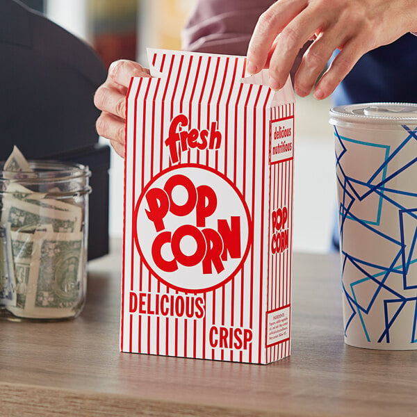 A hand holding a Great Western popcorn box.