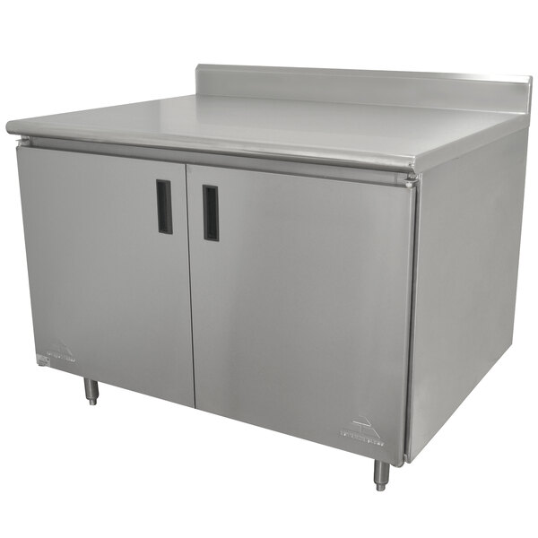 A stainless steel Advance Tabco work table cabinet with hinged doors.