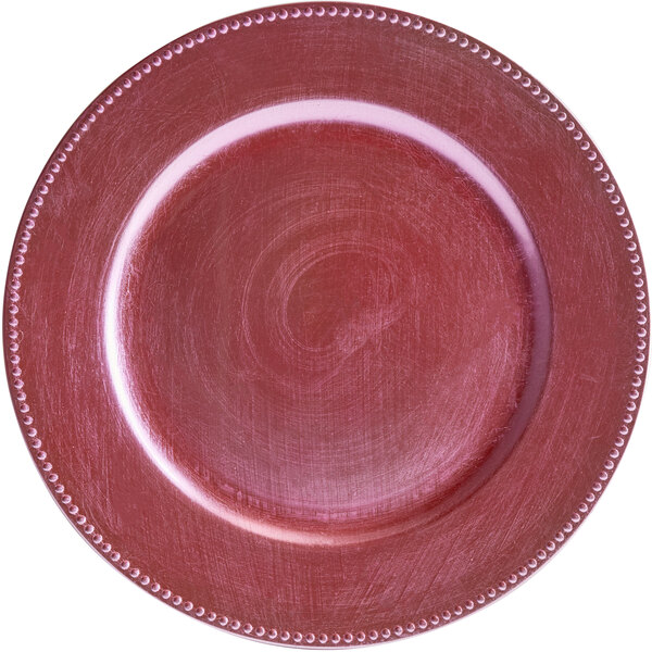 A pink plastic charger plate with a beaded edge.